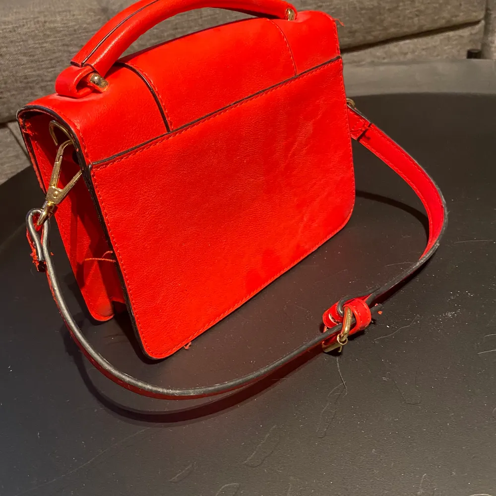 En röd liten handväska som passar perfekt till att göra en vanlig outfit lite coolare köpt på Lindex. Väskor.
