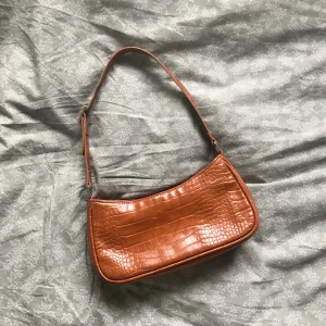 Väska Monki - Säljer en väska som tyvärr inte kommer till användning längre! Den är i jättefint skick och i dov orange