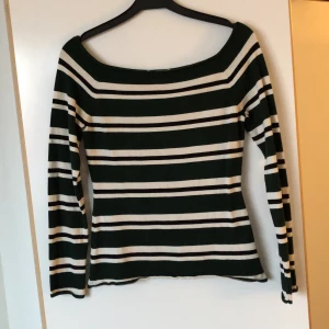 Randig stickad tröja från HM i storlek M - Denna tröja är mörkt grön, svart och vit och har en figurnära passform och bred ringning! Materialet är viskos och polyamid, den är mjuk och sparsamt använd.