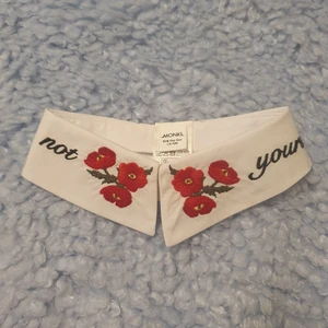 Söt krage🌹 - Vit krage med broderi av blommor och med texten "not yours" från Monki. Helt oanvänd. Frakten ingår i priset.