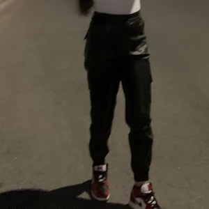 Svarta cargobyxor/skinnbyxor  - Säljer dessa fina PU läder cargobyxor i storlek 38 pga fel storlek. Nästan helt ny, använd ca 2 gånger. Mjukt material inifrån och många fickor. Pris kan alltid diskuteras :)