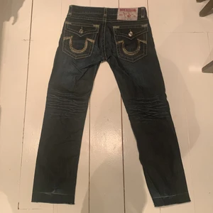 true religion jeans - Ett par true religion byxor. Dessa byxor har jag förlängt men är fof i bra skick och har används endast några få gånger. Midjemått = 43cm Innerbenslängd = 72cm Ytterbenslängd = 102cm