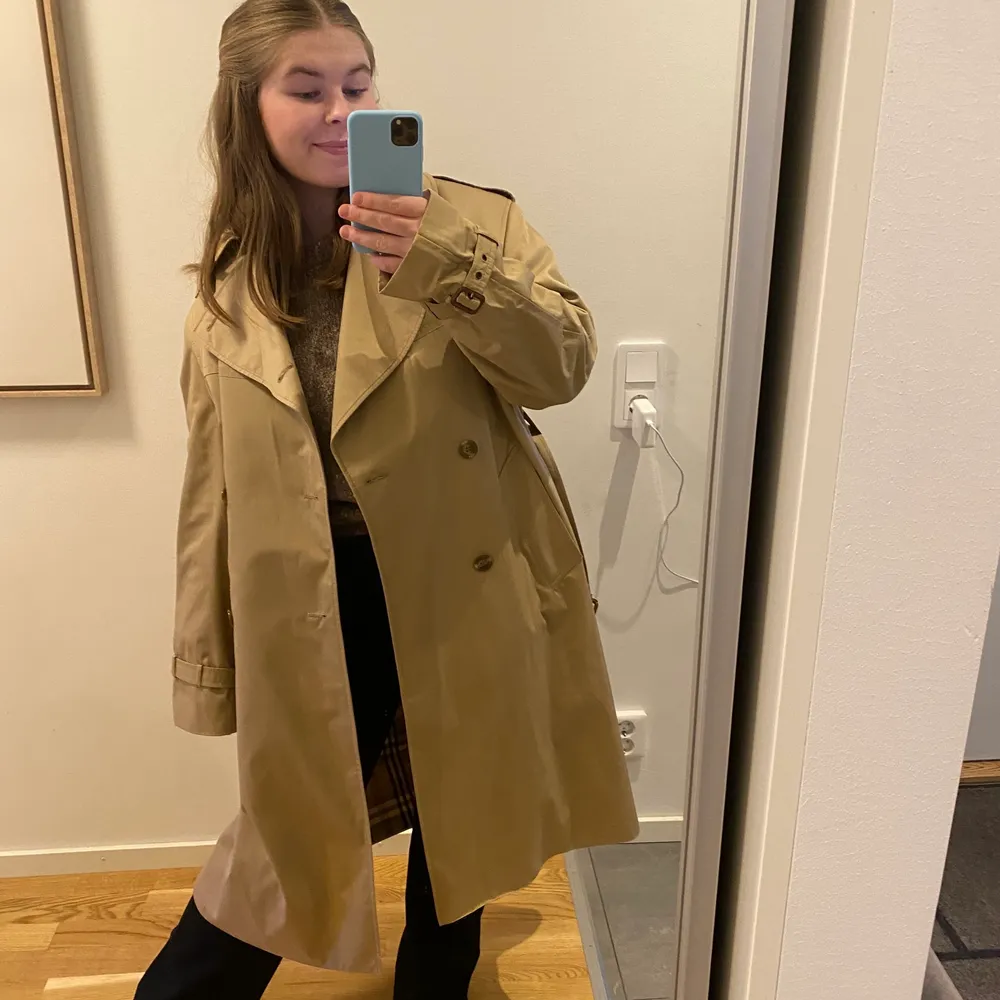 Superfin vintage trenchcoat från ASCOT, köpt vintage. Ska vara en strl 52, hittar dock ingen lapp. Jag upplever den som lite oz på mig som är M, så så snyggt. I riktigt fint skick, nästan som ny. Ser inget att anmärka på. Finns extraknappar i fodret och även ficka på insidan. Fodret inuti påminner om Burberry. Säljs för 280kr inkl frakt🤍🤍. Jackor.