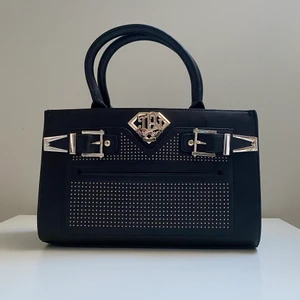 Svart handväska & axelremväska 👜  - Mått: 18 x 30 x 9 cm. Remlängd: 1.5 x 100 cm. Väskan är ungefär 6 år gammal. Jag har använt väska bara en gång. Väska kommer skicka med påse som tillhör väskan. Ordinarie pris är 3 000kr och nu är 1 050kr med gratis frakt 🚚.