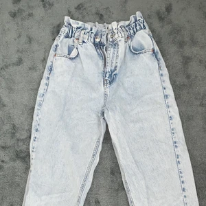 Jeans med ”volang/krås” upptill - Blå jeans med volang/krås upptill runt midjan. Strl 34. Så fina