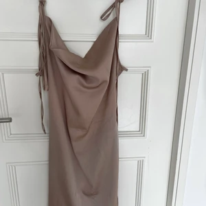 Satinklänning - Helt oanvänd satinklänning i schampagne/rosa färg. Så vacker och passar perfekt till sommaren. Går att justera i ryggen hur tajt man vill att den sitter. Storlek XS/S