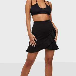 Svart kjol - Svart volangkjol från Nelly. Kostade 299 nypris och knappt använd. Knytning i midjan så passar från storlek s-m. 