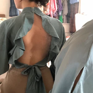 silkesblus  - jättefint blus i nyans av grön, öppen rygg och justerbart band att knyta bak! fråga om ni undrar något, köparen står för frakt:) 