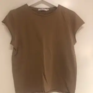Biege t shirt med ärmar som ser ut att vara lite ”avrivna” vilket ger den en liten rough stil. Bra skick!