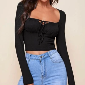 Svart topp med knytband  - Svart tight tröja i storlek S, funkar för M. Aldrig använd