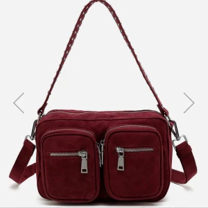 Noella väska  - Säljer min jättesnygga Noella väska! Så cool och unik vinröd färg, köpt för 700kr Säljer eftersom den inte kommer till användning längre. Otroligt bra skick och knappt använd, ser ut som ny! Köpare står för frakt