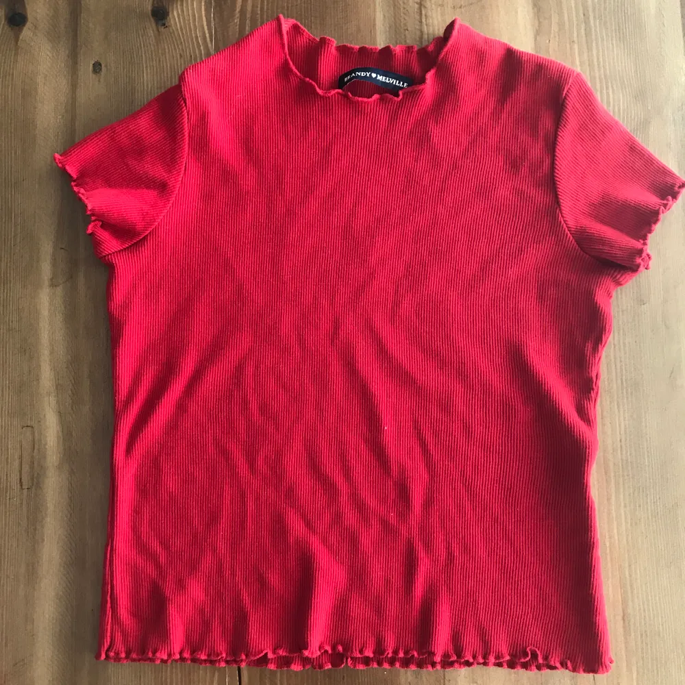 Excellent used condition. Bright red scarlet color. Soft and stretchy ribbed knit top in black with ruffled trimmings and a cropped fit.  80% viscose, 20% polyamide. Worn 2ggr then hand washed and machine dried. No holes, tears, rips, stains, snags, pilling, fading. Smoke and pet free storage space. No other flaws to note. Disclaimer: Please expect some general wear in all secondhand pre-owned items as they have lived a previous life, so do not expect a mint item.. Toppar.