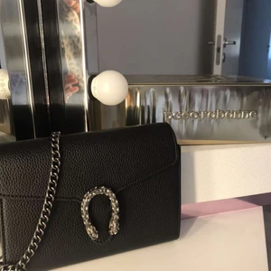 svart väska  - en svart väska med silver detaljer 