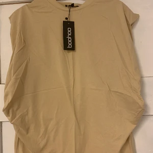 BEIGE T-SHIRT STL 36 - Jätte snygg och annorlunda t-shirt i beige. Storlek 36. Den är aldrig använd med prislappen kvar. Budgivning startar på 65kr i komentarsfältet, köp direkt för 120. Köpare står för frakt! (Budgivningen avslutas 1 april)