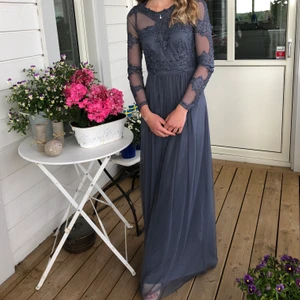 Balklänning blå/grå spets detaljer  - Säljer min fina balklänning från 2018, använd en gång. Strl 34 och är i en blå/grå färg med tyll och fina detaljer på överkroppen. Köparen står för frakt, kan även mötas upp i Stockholm. 400kr eller bud. Är 163cm lång💞
