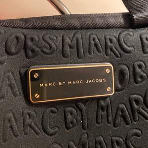 Marc Jacobs datorväska svart med guldiga detaljer! Använd endast fåtal gånger! Väskan har ett fack för datan och ytterligare ett fack för sladd eller vadqm känner för 😁