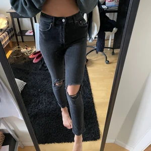 Svarta jeans från H&M med hål i knäna - Jättesnygga högmidjade svarta jeans från H&M med hål i knäna. Säljes då de inte används så mycket, använda fåtal gånger. 