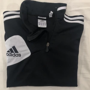 Adidas Sweatshirt Strl. EUR168/Small - Härlig träningströja som andas bra under och längsmed armarna. Dragkedja vid kragen och spännband vid midjan ifall man vill tighta till den. Köpt för ca 4 år sedan. Inte använd mycket och mycket bra kvalité😍