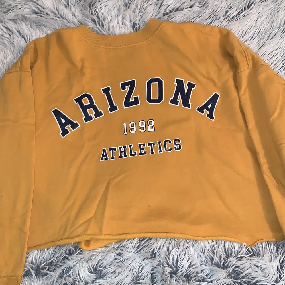 En gul-aktig tröja med texten ”Arizona”, ganska ny. Inte använd så ofta. . Tröjor & Koftor.