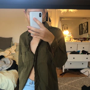 Grön skjorta strl S - Köpt second hand men har inte kommit till användning.  Bra kvalitet och bra skick! 