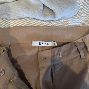 Bruna kostymbyxor från Nakd - Ett par skit snygga kostymbyxor i en brun färg. Säljer eftersom de har blivit för små. Köparen står för frakt💕