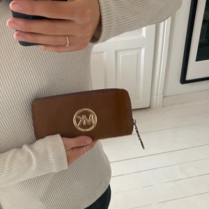Michael Kors plånbok - Säljer denna super fina Michael Kors plånboken då den inte kommer till användning💗  materialet är i brun mocka och har många innerfickor vilket gör den praktisk att använda⭐️ Ny kostar 1499kr