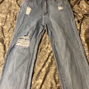 Blåa jeans från SHEIN - Ett par blåa straight jeans från SHEIN med hål på högra knät och även slitna på båda låren. Inte särskilt stretchiga men ändå sköna i materialet. Säljs eftersom dom inte passar längre💞 Nypris ca 150kr, aldrig använda endast testade, frakten står du själv för💞