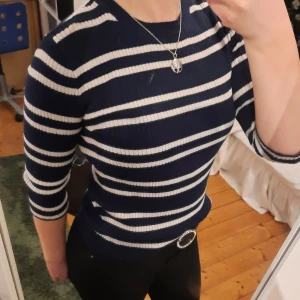 Marinblå randig tröja - Trekvartsärmad marinblå tröja med vita ränder från Ellos. Endast använd ett fåtal gånger, kommer tyvärr inte ihåg nypris men säljer den för 45 kr + frakt. (Står 0 kr i frakt då jag inte vet vad frakten kommer att kosta) Inga fläckar, missfärgningar eller hål. (Om något ser ut som en fläck är det på spegeln.)