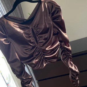 Tröja hm S brun croptop magtröja blus - Jättefin topp från HM i lite tjockare och glansigt matrial, strl S. Använd 1 gång och i fint skick! Hämtas i Segeltorp eller postas mot fraktkostnad 45kr