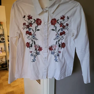 Skjorta - Vit skjorta med broderier och trumpetärm. Knappt använd. Från djur och rökfritt hem. Kan skickas mot fraktkostnad 