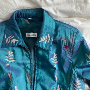 Jacka - Jättesnygg tunn vår/sommarjacka men otroligt mönster! Har ett jättefint skimrande tyg, men fina broderade detaljer. Köpt vintage.