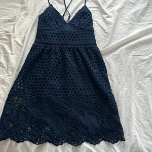 Marinblå klänning - Jättesöt marinblå spetsklänning med korsade band i ryggen från Abercrombie. Storlek XS. Kan mötas upp på Lidingö eller i centrala Stockholm