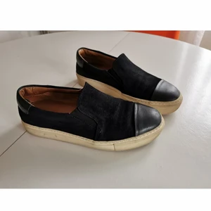 Malene birger slip-ons, stl. 37, svart - Malene Birger slip-ons Använd men i fint skick! Material: mockasinn och äkta läder  Stl: 37