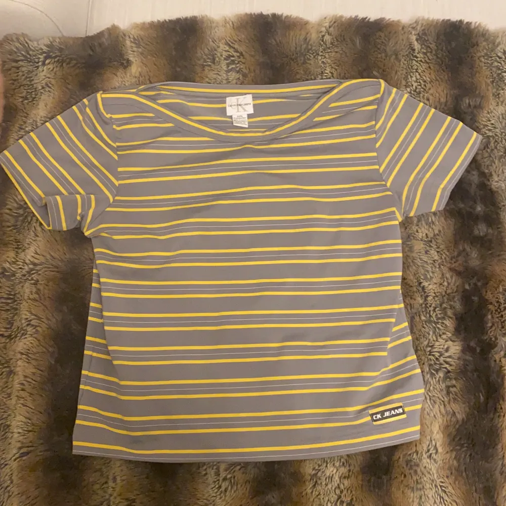  Randig grå och gul Calvin Klein Jeans T-shirt. Haft i flera år men används inte längre hihi.Storlek large men sitter bra på många storlekar beroende på hur du vill att Passformen ska vara. rött hjärta. T-shirts.