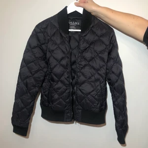 JACKA HOLLIES - Svart lättare dunjacka från Hollies. Logga på vänster arm. Inköpt för 799kr. Använd fåtal gånger. Liten i storleken, mer en M än L.