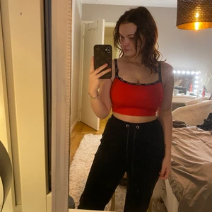 Röd croptop från levi’s - Säljer ett kort rött linne från Levi’s men svarta band. Storlek xs.