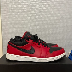 Jordan 1 low reverse bred, strl 44,5 - Användt ett par gånger, lite creasade och lite slitningar men annars ser dom bra ut.