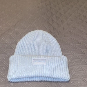 Ljusblå acneliknande mössa - Ljusblå mössa som liknar en acne mössa. Den är jätteskön att ha nu på vintern, men säljer då den inte kommer till användning 