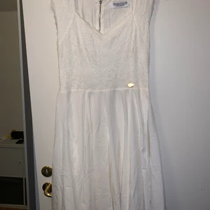 Chiara Forthi strl M - Superfin klänning med spets/vitt undertyg upptill och polyester/ vitt undertyg nertill, guld detaljer. Använde endast klänningen en gång på skolavslutningen andra åter på gymnasiet.