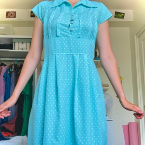 Fröken söt klänning - Turkos och färgglad klänning som använts men är i bra skick. Knapparna är dock lite slitna. Väldigt retro! 