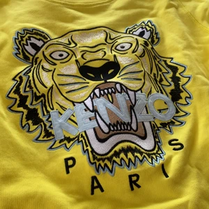 Kenzo tröja - En oanvänd kenzo tröja i XS köpt på NK för nått år sedan. Sjukt cool gul färg med ljusblåa detaljer i märket! 