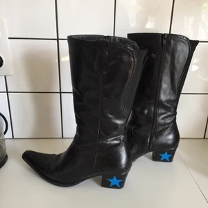 Cowboy boots  - Ett par snygga cowboy boots som är köpt secondhand, sen har jag målat tre blåa stjärnor på klacken. Det är vanlig målarfärg och sen har jag lagt på genomskinligt nagelak. Vet inte hur länge det håller!!❤️fint skick 