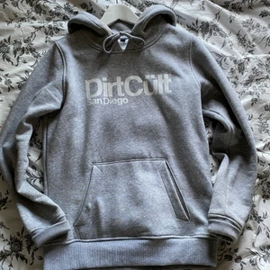 Grå dirtcult hoodie - Säljer en ljusgrå dirtcult hoodie storlek L dock mer som en M, använd fåtal gånger så därav är den som i nyskick.