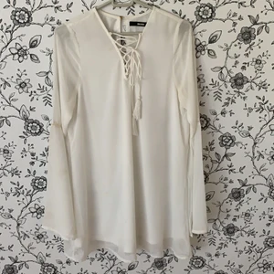 Bikbok flare klänning  - Jättefin vit flowig klänning med utsvängda ärmar. Snörning vid halsen som är borttagbar. Små broderidetaljer på ärmarna och sitter avslappnat på kroppen. Klänningen är ganska kort och går precis över rumpan på mig som är 175cm