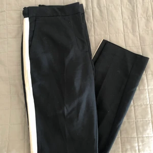 Kostymbyxa Zara - Svart kostymbyxa från Zara med ränder längs med benen i färgerna vit och beige. Storlek M men skulle säga S/liten M. Använda men i fint skick! 