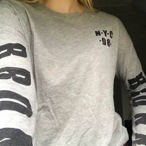 Tröja från Gina Tricot - Grå tunn tröja med texten ”Bronx” på båda armarna. Storlek XS men passar även S från Gina Tricot. Priset kan diskuteras!