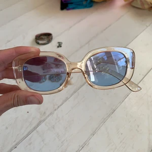 Solglasögon - Ljust rosa bågar med genomskinligt blå glas. Ascoola men passar inte mitt ansikte. Annars lättburna!