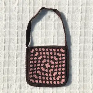 Supersöt liten väska i färgerna brun och rosa, handvirkad av mig🤎💗 Den är gjord på två mormorsrutor och ett axelband som kopplar ihop rutorna. Väskan har måtten 21x20 cm vilket är en perfekt storlek för små utflykter!