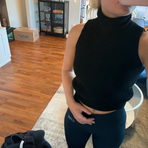 stickad tröja  - Svart stickad tröja utan armar med polo krage. superfin att ha som den är eller med en blus under. alldrig andvänd