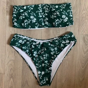 Blommig bikini - En bikini i ett superfint mörkgrönt tyg med blommor från shein. Köpt av en tjej här på plick men den var tyvärr för stor för mig som är en storlek S. Sitter nog som en smäck på en storlek M🌿🤍